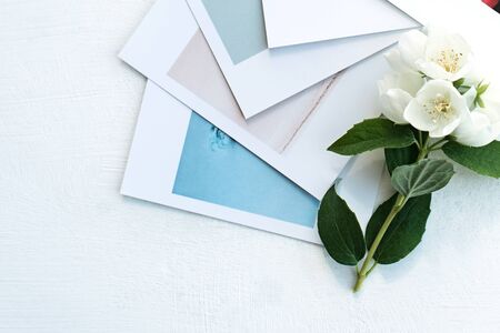 printed photos, cards, on a blue background with a white flower. Mock up.の写真素材