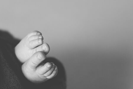 feet of the newborn baby, fingers on the foot, maternal care, love and family hugs, tendernessの写真素材