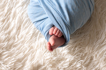 feet of the newborn baby, fingers on the foot, maternal care, love and family hugs, tenderness