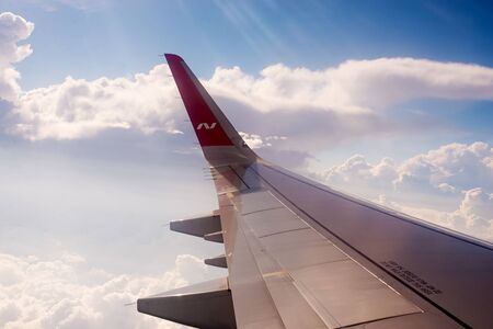 Moscow, Russia, July 8, 2019. View from the porthole on the wing of a Boeing with the Nordwind logo and clouds. airplane trip.のeditorial素材