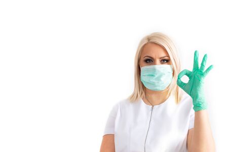 Doctor in a medical mask and green rubber gloves. Virus, coronavirus. protection. Sterile equipment for the medical and beauty industries. Copy space, place for text.の写真素材