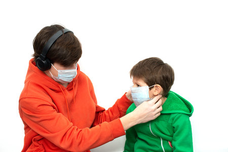 children putting on a medical mask in bright clothes. isolated, copy space. Coronavirus protection.