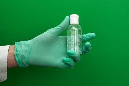 Hand in latex green medical protection gloves white sanitizer. Coronavirus optimistic hygiene...