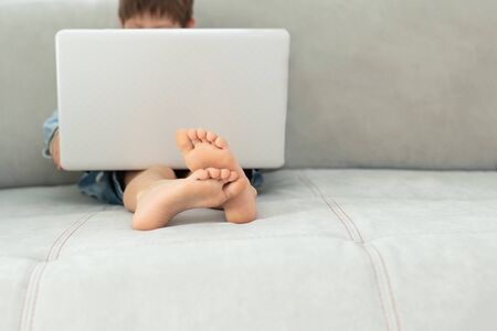 Kids and gadgets. Distance learning during isolation during quarantine in coronavirus. Boy and laptop at home. Lifestyle.の写真素材