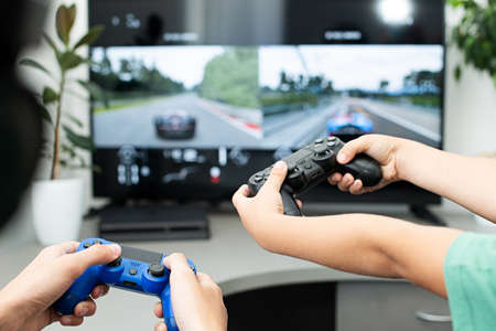 Teenager boy online plays a computer game with headphones and a joystick, game console.のeditorial素材