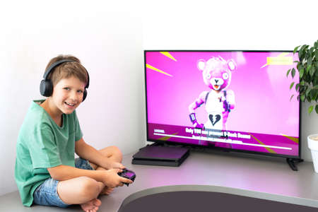 Teenager plays a computer game with headphones and a joystick, game console.のeditorial素材