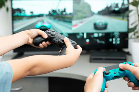 Teenager boy online plays a computer game with headphones and a joystick, game console.のeditorial素材