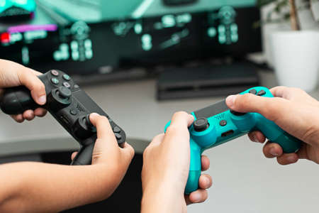 Teenager boy online plays a computer game with headphones and a joystick, game console.のeditorial素材