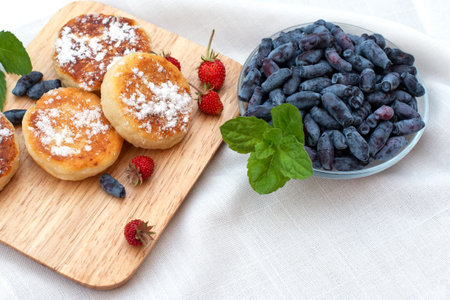 honeysuckle berries on a concrete background. Summer blu berries. Green backgroundの写真素材
