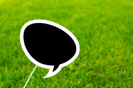 Black chalk board for inscriptions on green grass background. Copy space. Empty place for textの写真素材