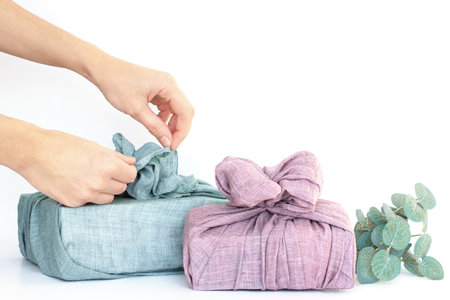 wrapping gifts in fabric for Christmas in furoshiki style. Eco friendly concept. DIYの写真素材