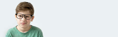 Banner. Surprised boy in a green T-shirt and glasses. Copy space. Children's emotionsの写真素材