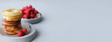 Round baked donut with strawberries on a gray concrete background. minimalism. copy spaceの写真素材