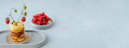 Round baked donut with strawberries on a gray concrete background. Minimalism. Copy spaceの写真素材