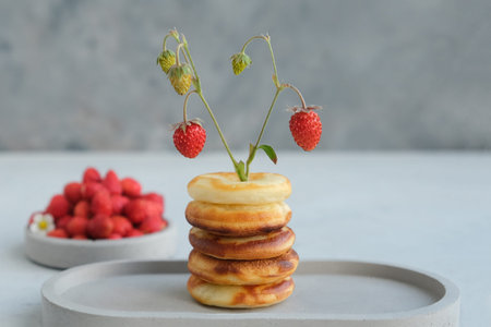 Round baked donut with strawberries on a gray concrete background. Minimalism. Copy spaceの写真素材