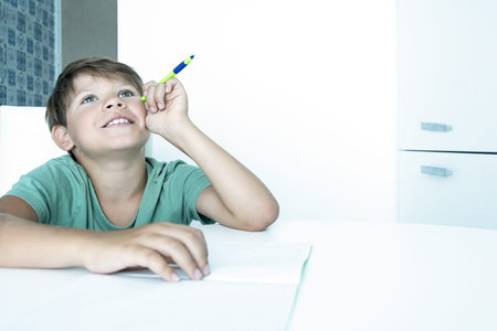 Smiling boy with book does school homework. Back to school. Unhappy schoolboy with textbooks....