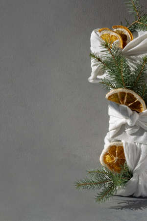 Japanese packaging of furoshiki in eco-friendly fabric. New Years minimalistic dark gray trending background 2022. Recyclable materials for decoration. Plastic free, hand made gift package for Christmas, birthday, Easter and other festive occasionsの写真素材