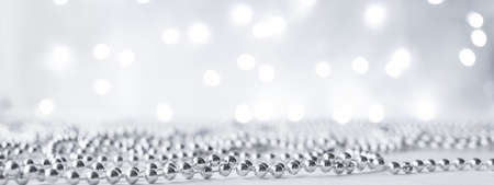 New year and Christmas new, spruce, fer tree background with silver garlands with lights with bokeh in blur. Gray neutral colors with copy space and mock up.の写真素材