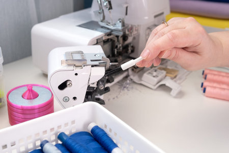 taking measurements on the fabric. Seamstress sewing on the sewing machine in small studio. Fashion...