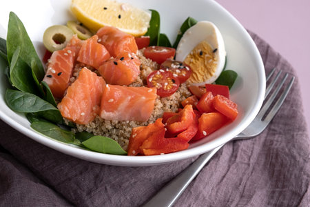 bowl plate with poke dish. fresh salmon, quinoa, spinach, lemon for a healthy diet. copy space