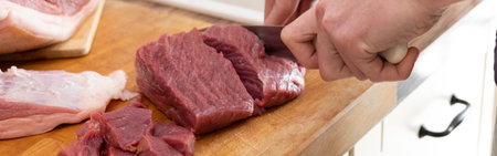 Real men cutting fresh raw meat on board in white kitchen. Preparing pork meat, cooking.
