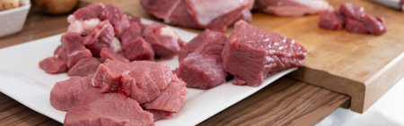 Real men cutting fresh raw meat on board in white kitchen. Preparing pork meat, cooking.