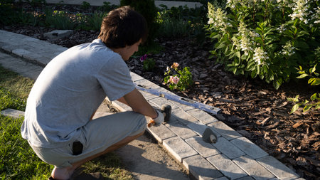 Laying paving stones on cement mortar. Laying a garden path made of tiles. Self-laying of concrete...