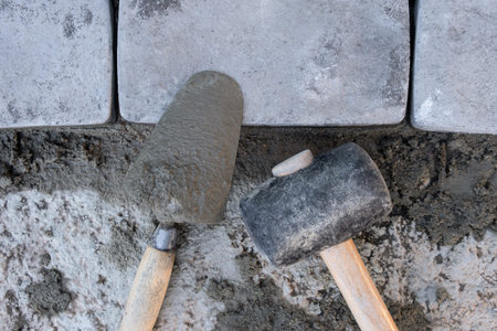 Laying paving stones on cement mortar. Laying a garden path made of tiles. Self-laying of concrete...