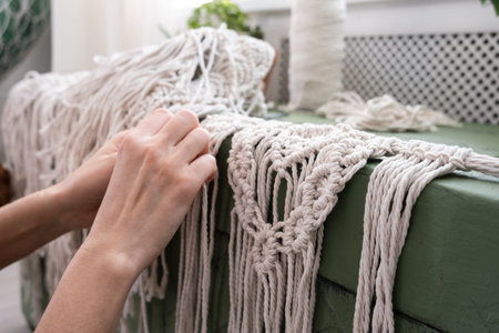 women's hands weave macrame panels. cotton threads, yarn for the manufacture of hand-made products...