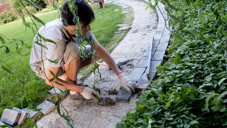 Laying paving stones on cement mortar. Laying a garden path made of tiles. Self-laying of concrete...