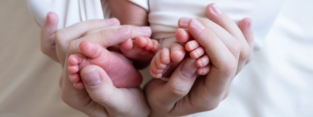 Mom and dad hands hold small legs of their two newborn twin babies. multiple pregnancy
