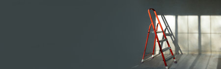 Red ladder stepladder in empty room, without renovation. gray background. Repair conceptの写真素材
