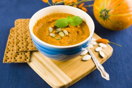 yellow pumpkin soup in a blue plate on a blue background. Food vegan, dietの写真素材