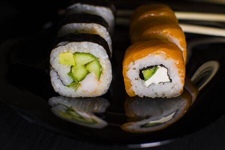 Sushi rolls with salmon and avocado on a dark backgroundの写真素材
