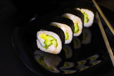 Sushi rolls with salmon and avocado on a dark backgroundの写真素材