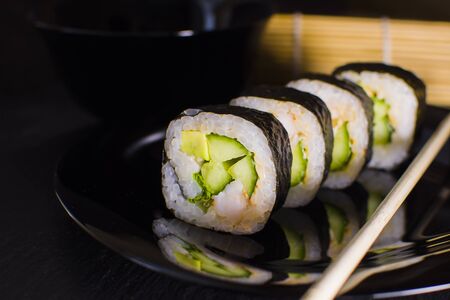 Sushi rolls with salmon and avocado on a dark backgroundの写真素材