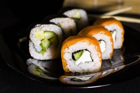 Sushi rolls with salmon and avocado on a dark backgroundの写真素材