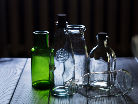 A set of glass empty bottles on dark wooden background. For interior decorの写真素材