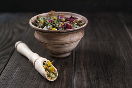 Herbal tea ingredients with hip roses, chamomile, herbs on wooden tableの写真素材