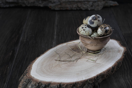 Quail eggs in clay pot on dark background. Eco products. Healthy foodの写真素材