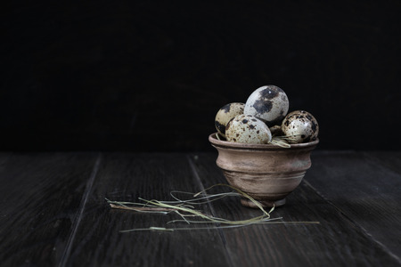 Quail eggs in clay pot on dark background. Eco products. Healthy foodの写真素材