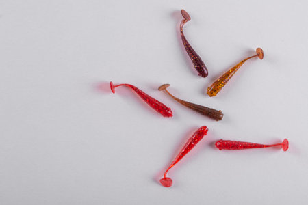Little colorful silicone fishing baits on white background