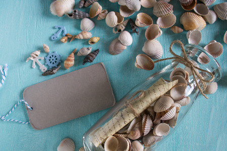 Summer background on wood with message in bottle and tag for text.Marine concept.の写真素材