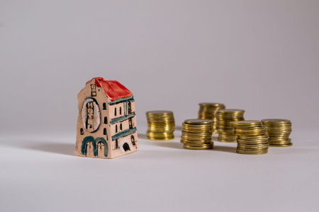 Business concept. Model of house  hotel with coins on white background