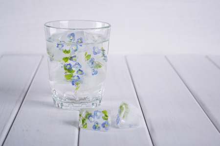 Ice cubs with frozen flowers in glass of water for cosmetic skincare useの写真素材