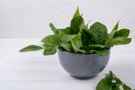 Fresh garden organic spinach in bowl  on white background ready for salad.の写真素材
