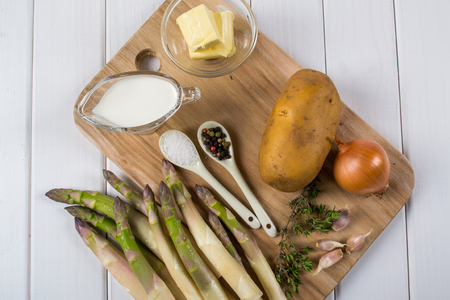 Vegan ingredients for cooking soup from asparagus. Recipe on white wooden tableの写真素材