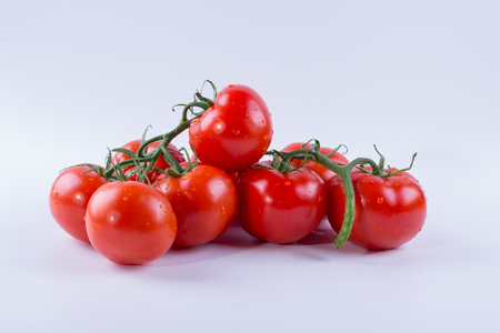 A bunch of tomatoes on a white backgroundの写真素材