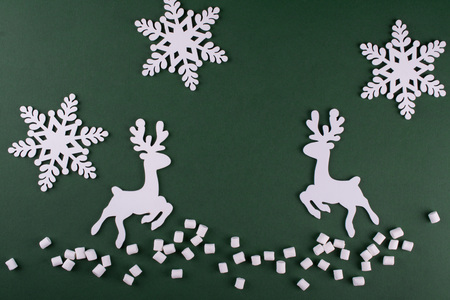 Winter composition with  deers and snowflakes. On green background. Christmas card. Wooden figuresの写真素材