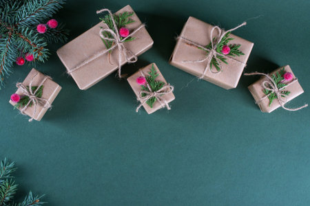 Christmas background. Packing  gifts in vintage beige craft paper and natural decor. Branches of fir...